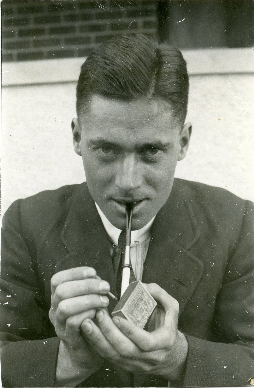 Howard Florey lighting a pipe, c1920s