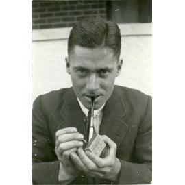 Howard Florey lighting a pipe, c1920s